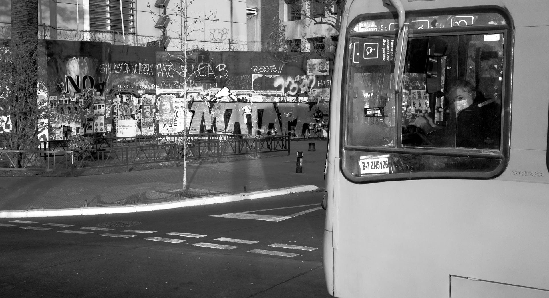 bus driver with mask in front of a graffiti wall