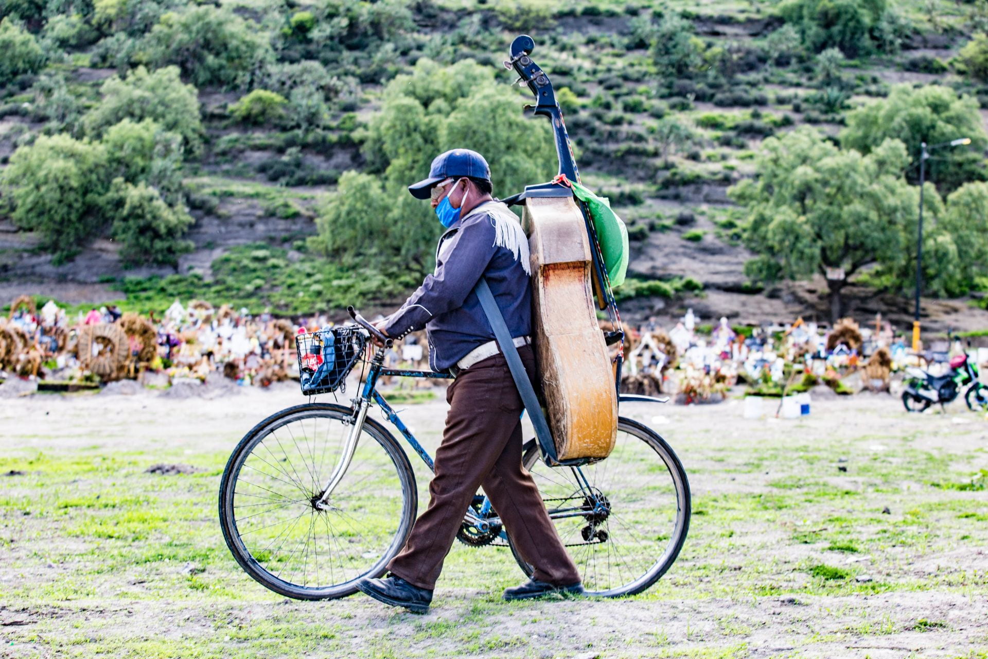 man with bicycle and musical instrument on his back