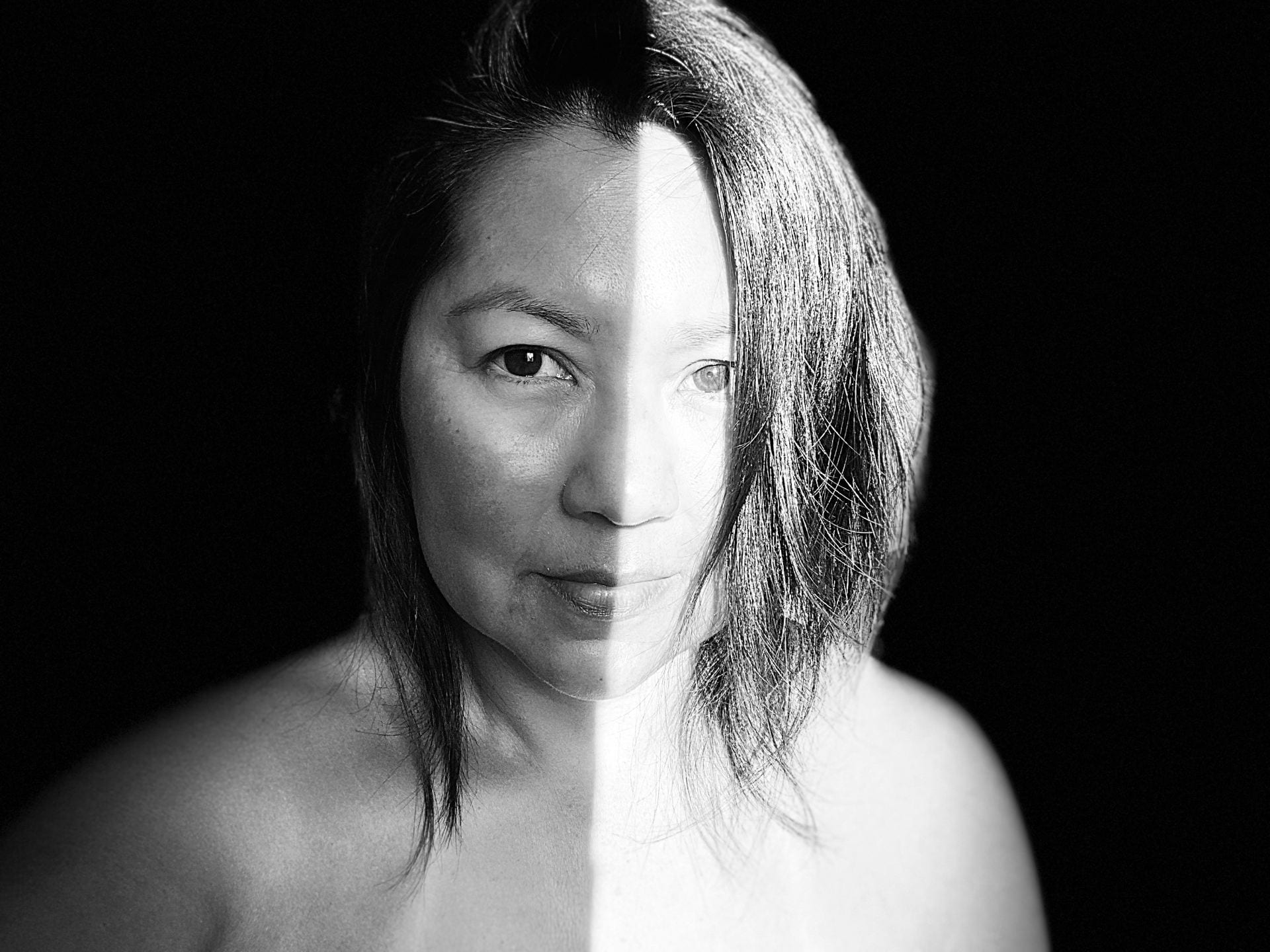 portrait of a woman with a symmetrical shadow on her face and shoulders