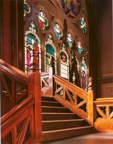 Ascending stairway looking towards colorful stained glass windows